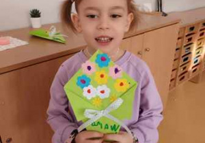 Tosia prezentuje wykonany przez siebie z kolorowego papieru bukiet dla Babci i Dziadka