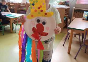 Chłopiec wynosi na wystawę swojego klauna wykonanego podczas zabawy plastycznej