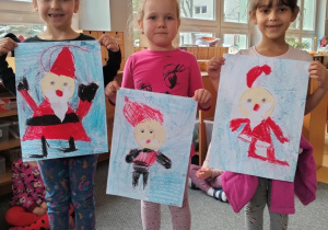 dziewczynki prezentują mikołaje malowane pastelami