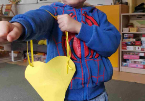 Chłopiec prezentuje wykonaną torebkę w kształcie serca