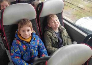 Chłopcy siedzą w autokarze podczas jazdy do teatru
