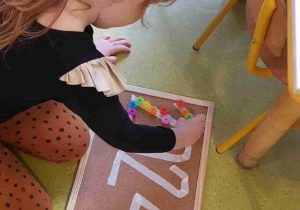 Dziewczynka układa napis 2024 z kolorowych rzepów