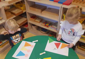 Dzieci przyklejają trójkąty na kartkę