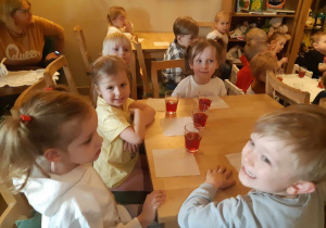 Dzieci siedzące przy stole podczas poczęstunku