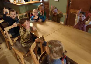 Dzieci siedzą przy stole i oczekują na przedstawienie w "Baśniowej Kawiarence"