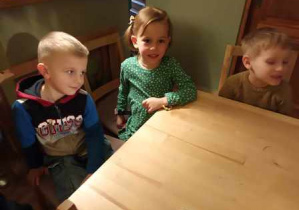 Dzieci w oczekiwaniu na rozpoczęcie przedstawienia siedzą przy stoliku w "Baśniowej Kawiarence"