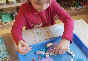 Dziewczynka buduje z klocków