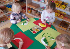 Dzieci malują farbami papierowe talerzyki