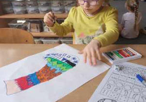 Dziewczyna rysuje ilustrację skarpetki z wykorzystaniem gry matematycznej 'Wyturlaj mnie"