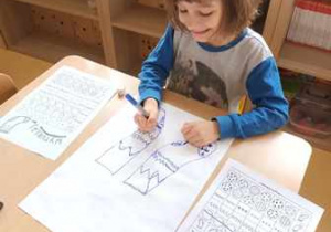 Chłopiec rysuje ilustrację skarpetki z wykorzystaniem gry matematycznej "Wyturlaj mnie"