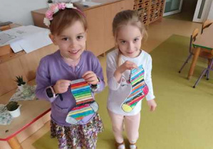 Tosia i Anielka trzymają w dłoniach pomalowane przez siebie sylwety skarpetek