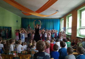 Dzieci tańczą taniec pokazywany przez tancerkę