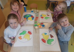 Dzieci w odpowiedniej kolorystyce malują kontynenty