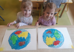 Dziewczynki pastelami rysują kolorową Ziemię