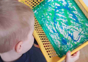 Chłopiec maluje Ziemię szklanymi kulami