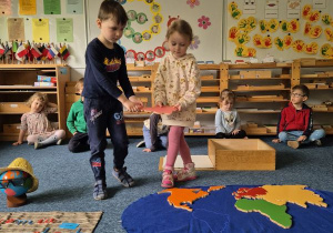 Chłopiec i dziewczynka układają kontynent na mapie świata
