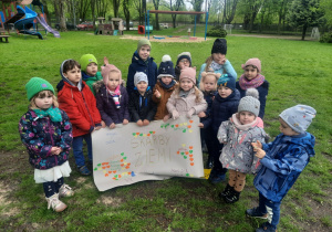 Dzieci prezentują plakat przygotowany z okazji Dnia Ziemi