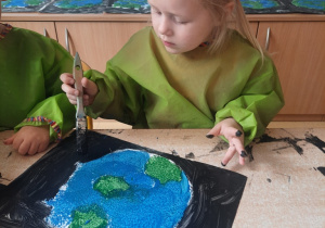 Laura maluje Ziemię farbami