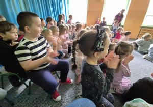 Dzieci siedzą i słuchają koncertu gry na bębnach