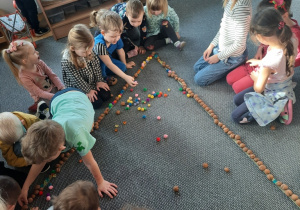 Dzieci układają trójkąt z materiału przyrodniczego