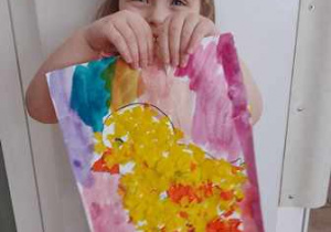 Dziewczynka prezentuje wykonaną przez siebie pracę plastyczną przedstawiającą kurczaczka