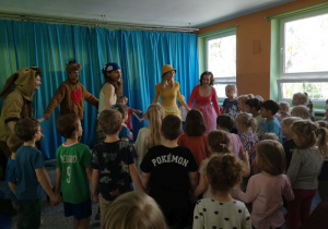 Dzieci tańczą w kole wraz z aktorami