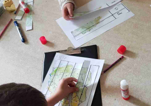 Dzieci przyklejają paski papieru z wyciętej karty pracy