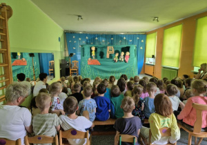 Dzieci oglądają przedstawienie, na scenie kukiełki podczas przedstawienia