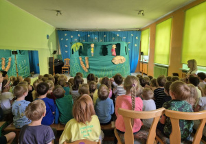 Dzieci oglądają przedstawienie, na scenie kukiełki podczas przedstawienia