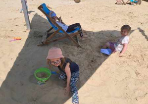 Dziewczynki korzystają z zabaw sensorycznych w dużej piaskownicy