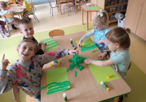 Dzieci przyklejają paski zielonej bibuły