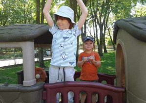 Chłopcy podczas zabawy w ogrodzie przedszkolnym korzystają ze sprzętu ogrodowego