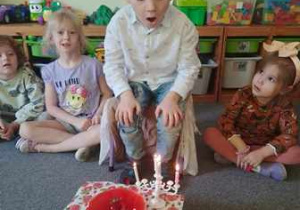 Brunon zdmuchuje świeczki z urodzinowego tortu