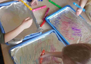Dzieci malują mazakami folię aluminiową