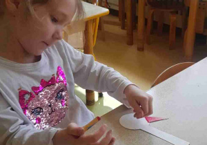 Dziewczynka maluje dziób bociana