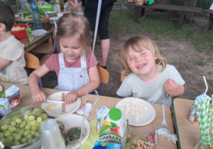 Dzieci siedzą przy stolikach podczas poczęstunku