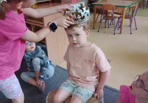 Dziewczynka wkłada koronę na głowę Frania