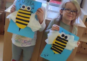 Dziewczynki trzymają swoje pszczółki i pozują do zdjęcia