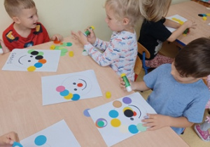 Dzieci przyklejają kolorowe kółka