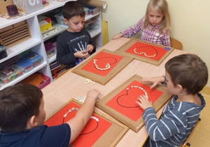 Dzieci w czasie układania serc dla Marii Montessori