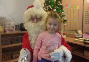 Dziewczynka otrzymuje prezent od Świętego Mikołaja.