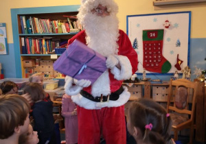 Święty Mikołaj trzyma w rękach prezent
