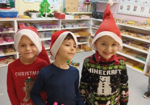 Dzieci ubrane w czapki Świętego Mikołaja czekają na jego przyjście