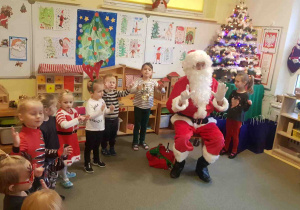 Dzieci śpiewają Mikołajowi piosenkę na powitanie.