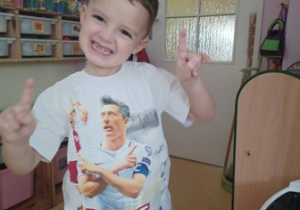Chłopiec prezentuje koszulkę, na której znajduje się podobizna Roberta Lewandowskiego