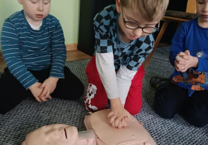 Dzieci ćwiczą resuscytację krążeniowo-oddechową z wykorzystaniem fantomu