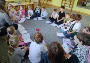 Dzieci siedzą w kręgu podczas warsztatów