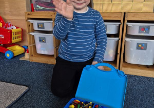 Chłopiec pozuje do zdjęcia z klockami Lego