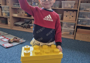 Chłopiec pozuje do zdjęcia z klockami Lego