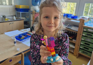 Dziewczynka pozuje do zdjęcia z klockami Lego